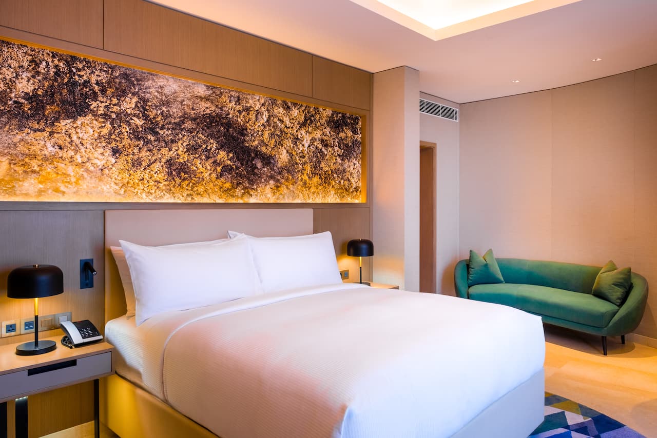 Contemporary business suite bedroom with king bed and lounge seating