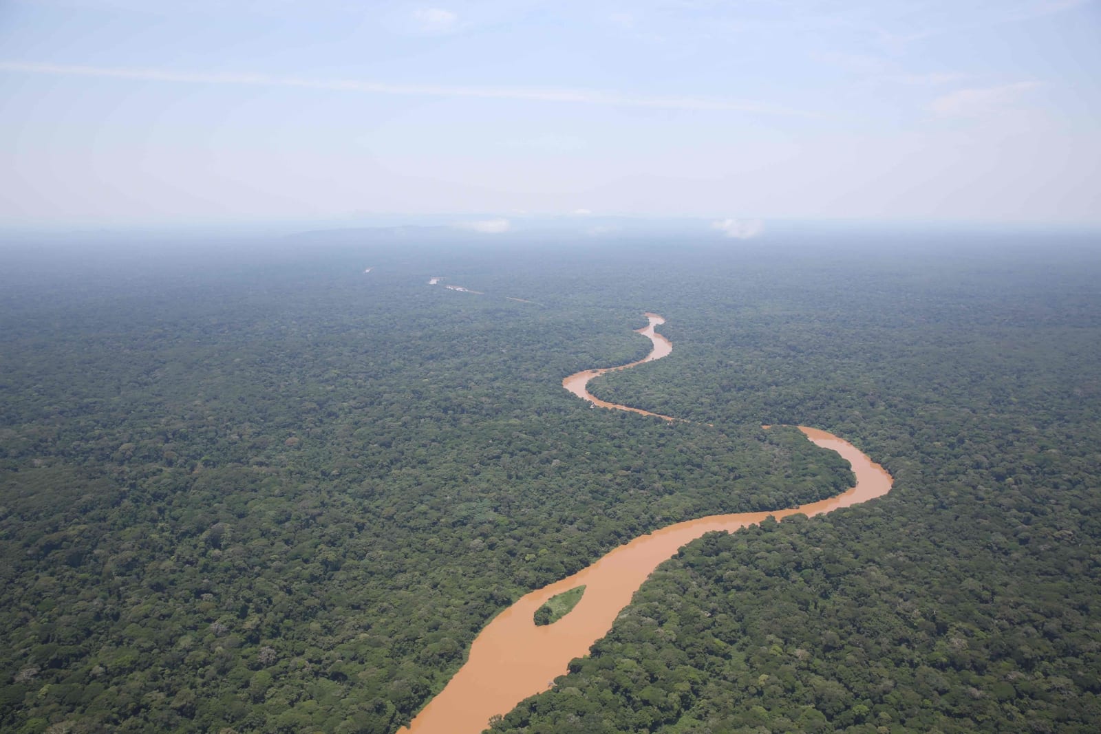 Aerial view of winding river through Gangala na Bodio savanna-forest landscape in Ituri Province, DRC