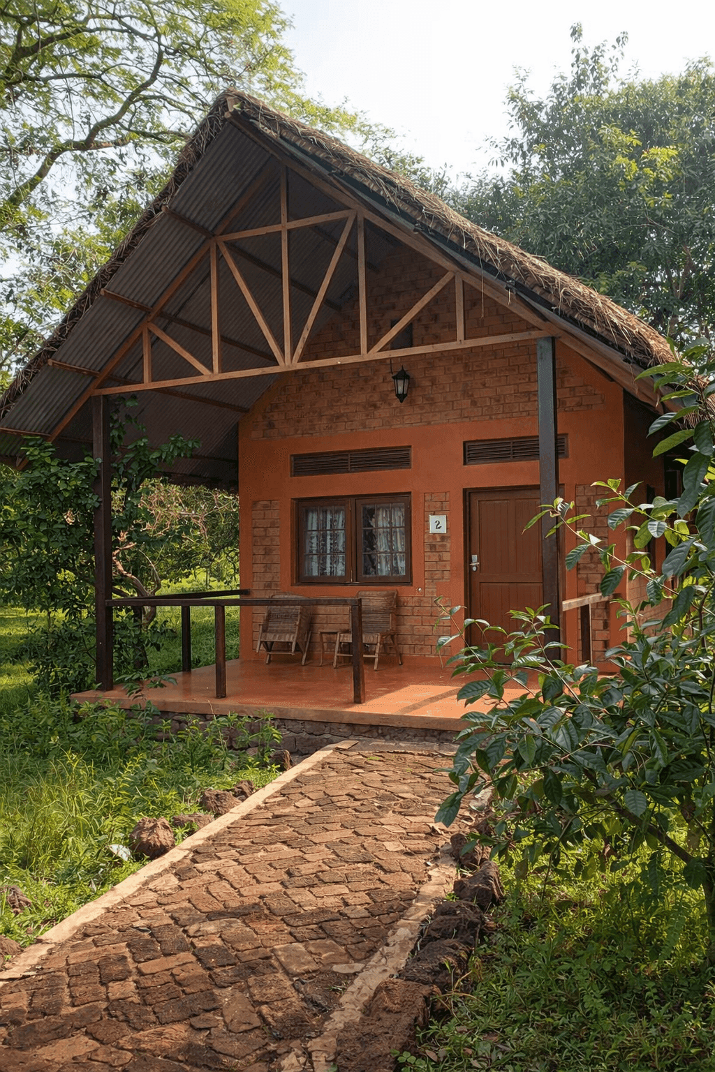 Garamba Lodge eco-cottage with thatched roof surrounded by tropical gardens