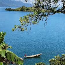 View of Idjwi Island on Lake Kivu with green hills and fishing boats