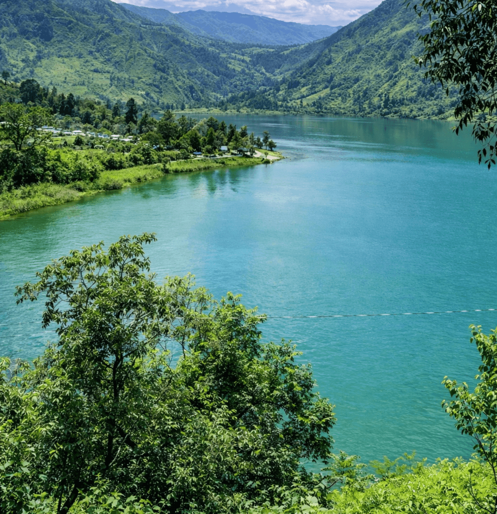 Inkisi River flowing through Kimpese with turquoise waters, lush green mountains and traditional villages