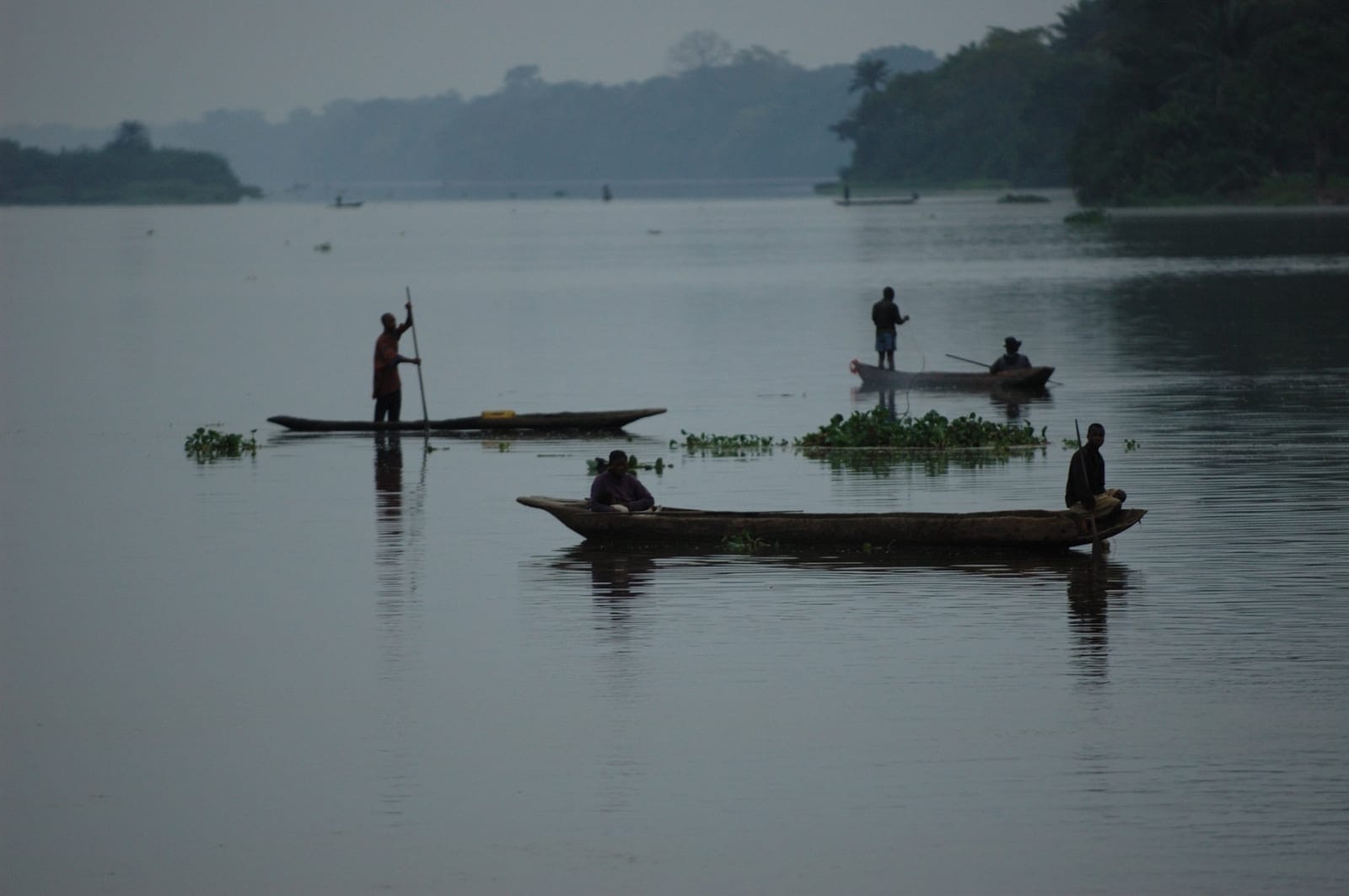 Kasai River at dusk with traditional canoes and fishermen