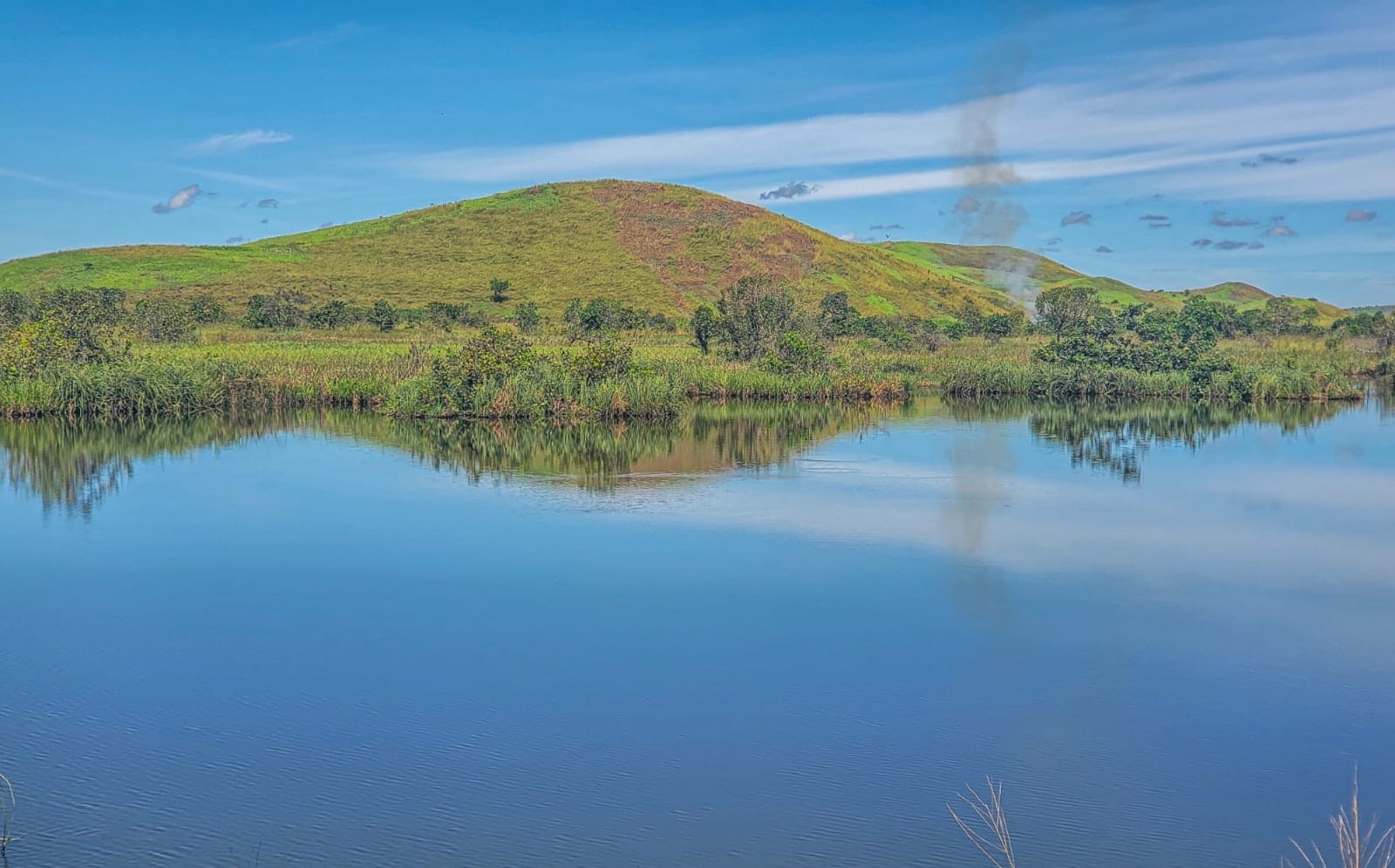 Scenic Lac Mbinza with reflective waters and green hills