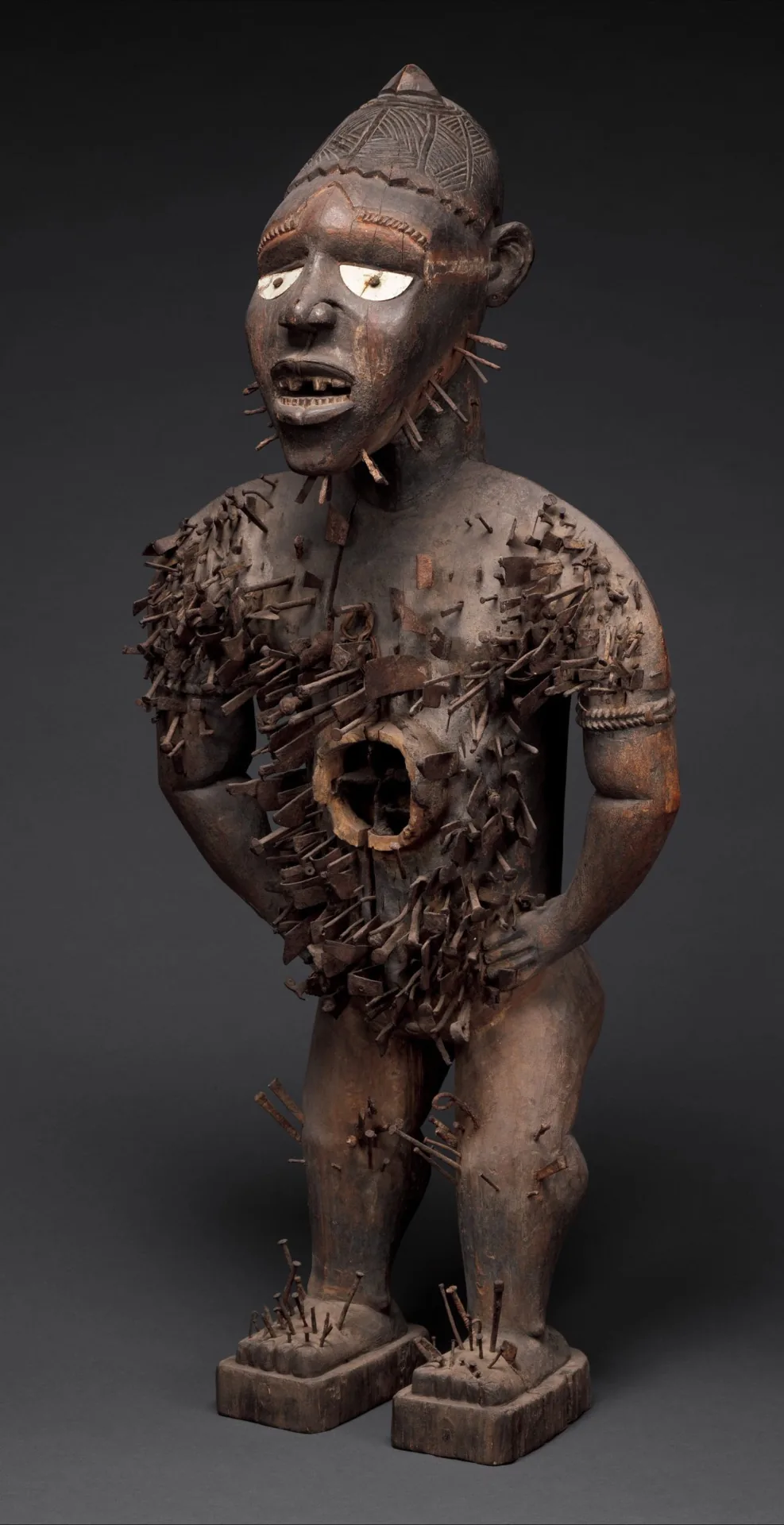 Kongo nkisi nkondi nail-fetish power figure carved in wood, studded with iron blades and nails