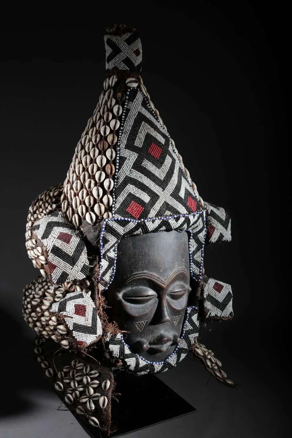 Kuba royal beaded mask covered in cowrie shells and geometric beadwork from central DR Congo