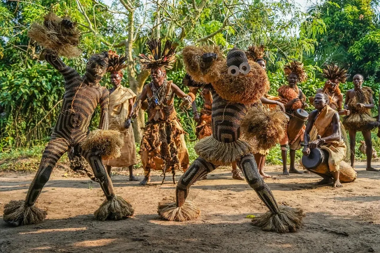 Traditional masked dancers and drummers in ceremonial regalia — deep Congo culture trail across Kasai and Ituri