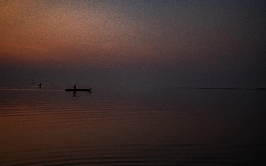 Sunset over Upemba lake with fishing boat
